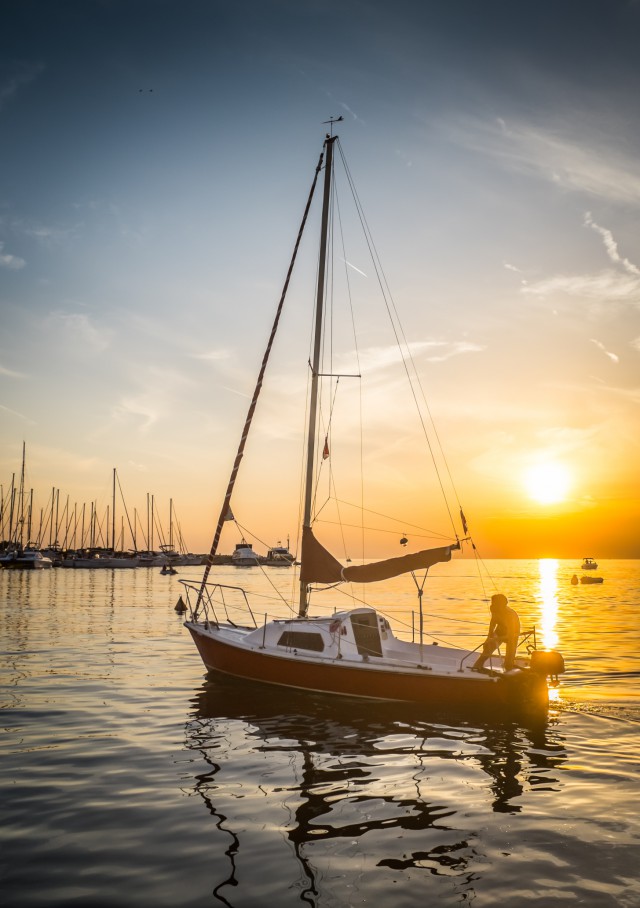 Luxury yachts and ships in the marina at sunset.